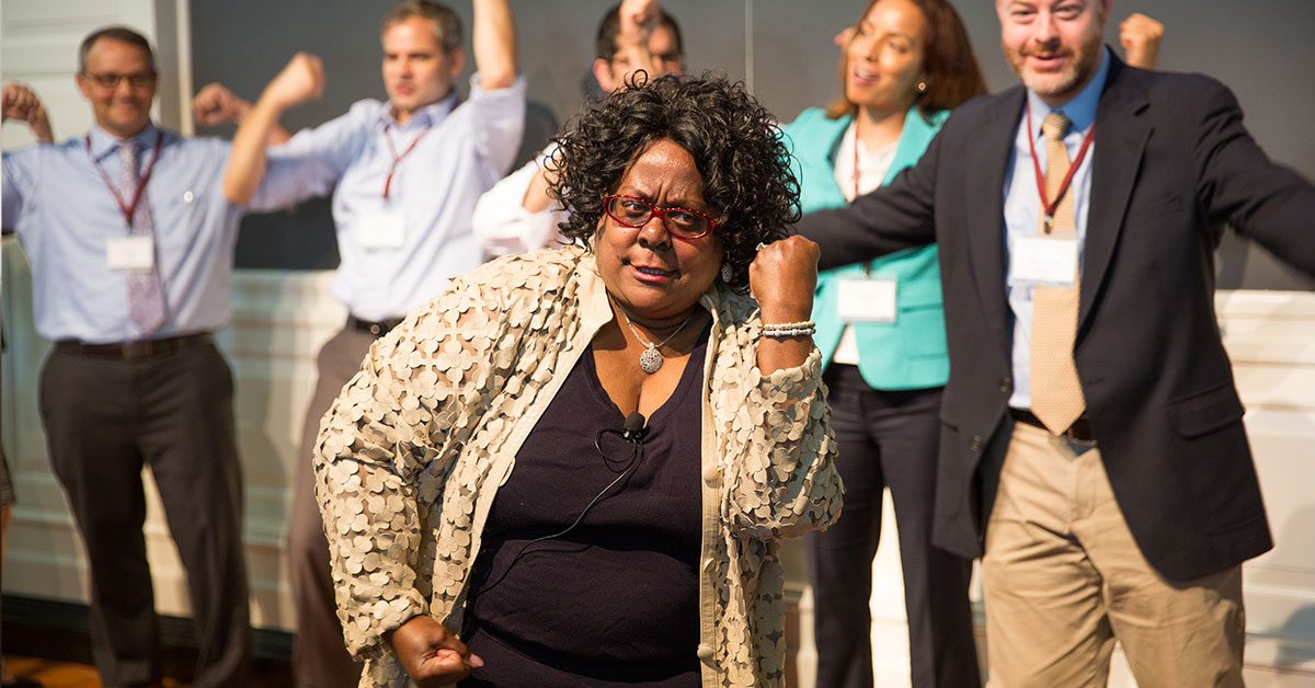 A professor at the Harvard Graduate School of Education leads the room in a dance to ground participants in movement and a connective experience