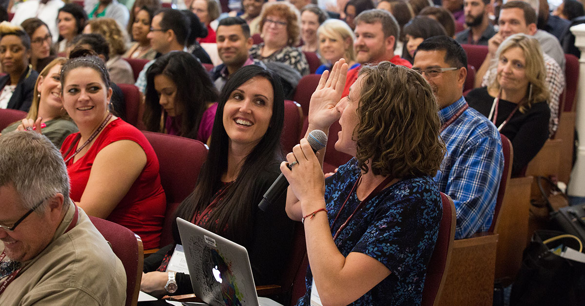 A Texas principal addresses a full lecture hall of school leaders at the Harvard Graduate School of Education