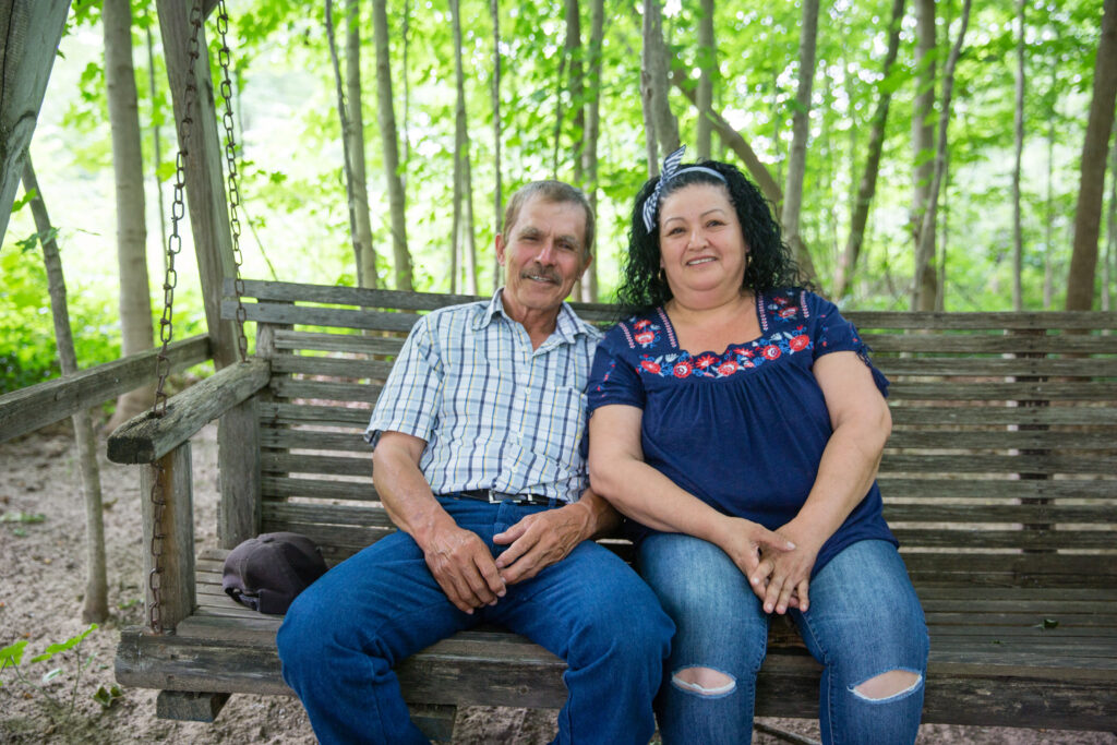 Raquel's parents sit on a swing in their patio