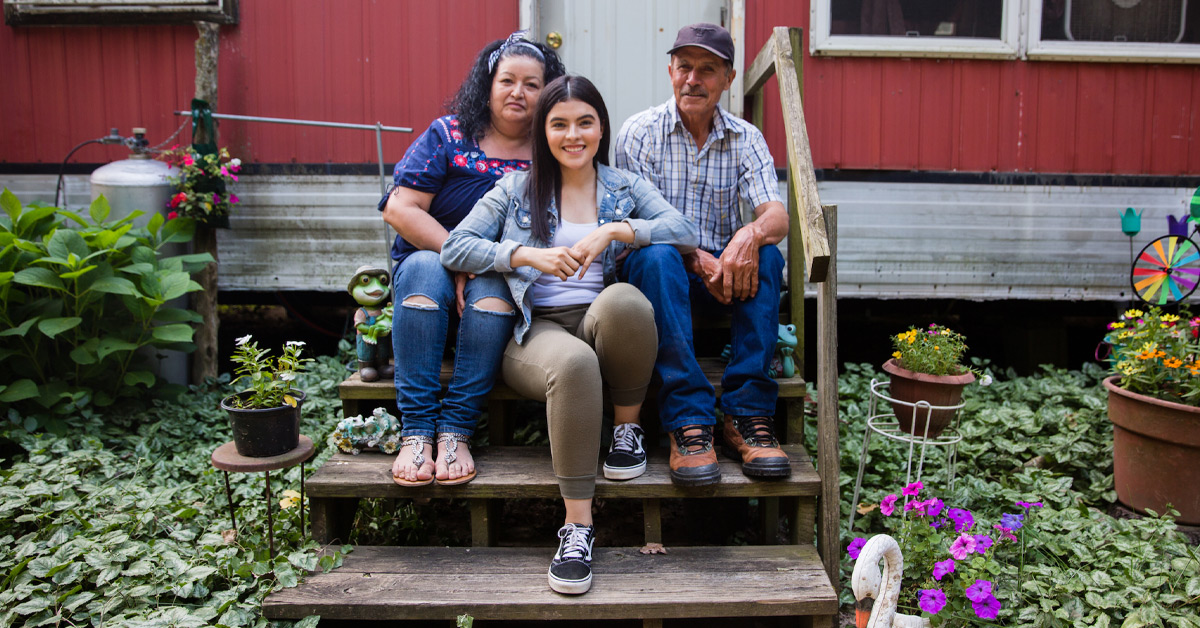The Pérez family sits on the steps outside of their mobile home in Benton Harbor Michigan