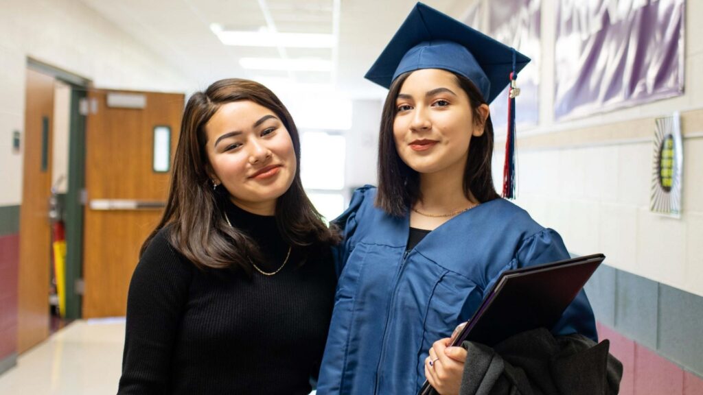 Two students at the PACE Center (Pearland's Alternative Choice for Education) look proudly into the camera on graduation day.