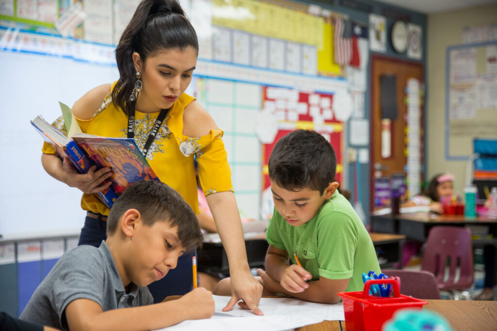 Raquel Perez, a Charles Butt Scholar, provides instruction to two of her students in a classroom.