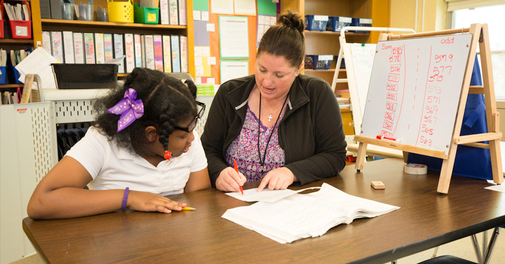 A teacher mentors a student one-on-one.