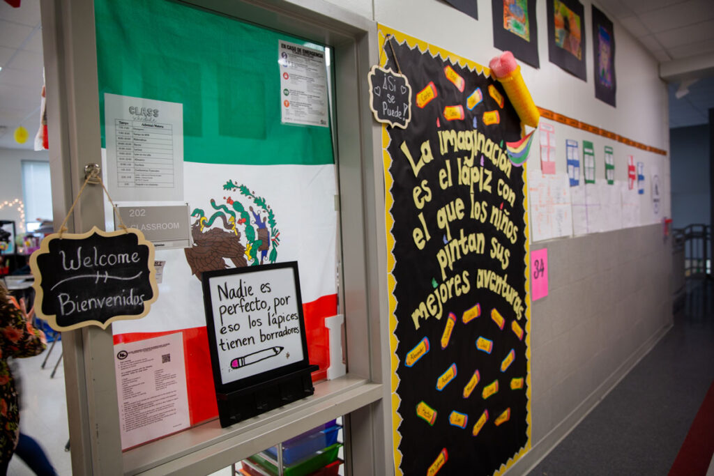 The door to Uriel Iglesias' fourth-grade bilingual classroom is covered in Mexico flag and welcome message in English and Spanish.