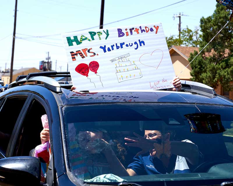 A sign from a camera in the parade reads "Happy birthday Mrs. Yarbrough."