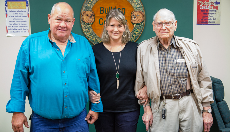 Lyford CISD School Board President Alison Busse Savage shares a moment in the board room with her father, Gary, and Grandfather, Buck.