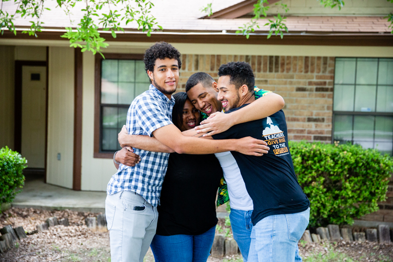 The Fisher family squeezes into a group hug in front of their home in Killeen, Texas.