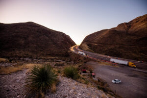 Cars drive down a highway pass through the Franklin Mountains