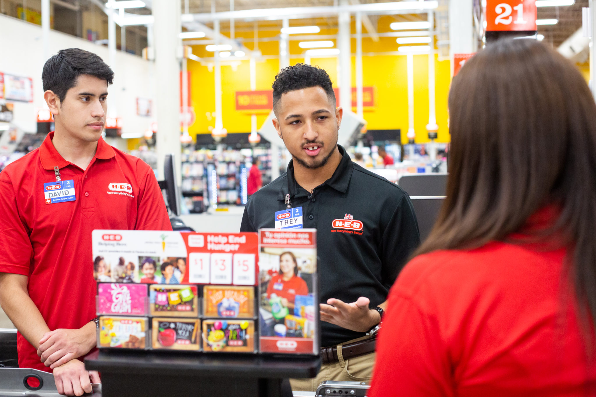 Trey Fisher trains two new partners at the H-E-B grocery store in Austin Texas where he servers as a manager.