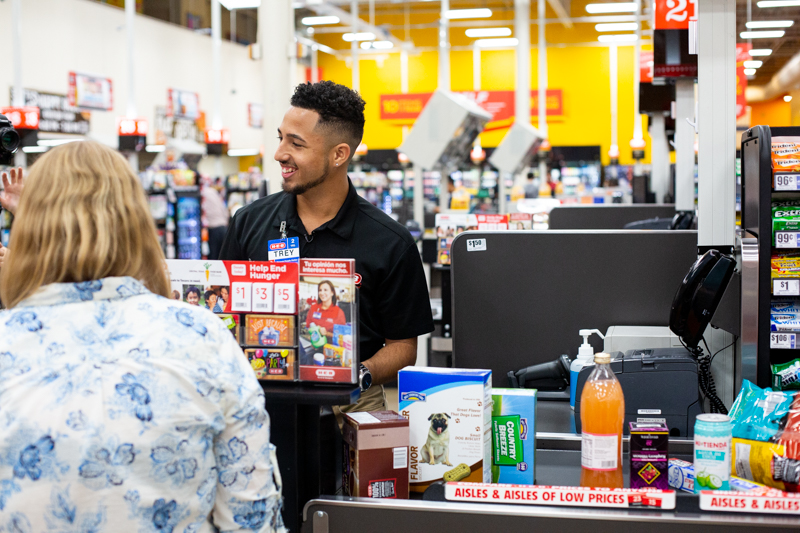 Pay assists a customer at the register at H-E-B.