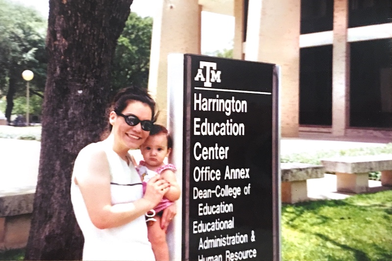 Anna’s mother holds her in front of the School of Education in College Station where she graduated in 1993. 