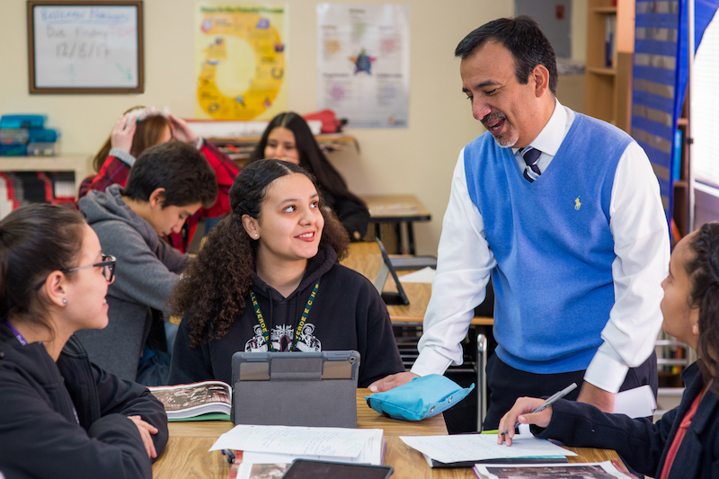 Paul Covey, Principal at Valle Verde Early College High School, chats with a student.