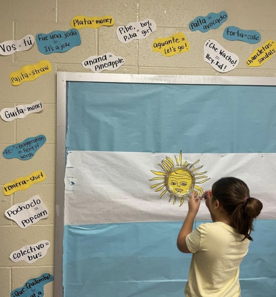 Argentina_kid in classroom with the backdrop of the Argentina flag